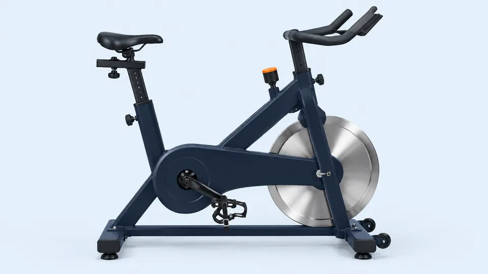 Spinningcykel set fra siden med svinghjul foran, modstandsknap og justerbar sadel og styr